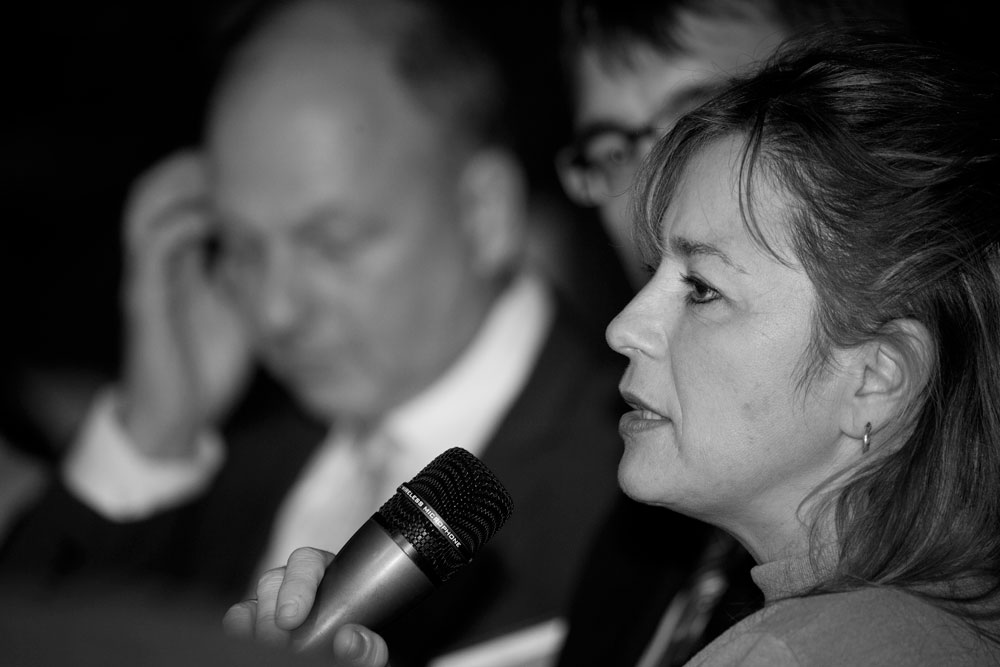 Schwarz Weiss Bild einer Frau mit Mikrofon auf einer Bühne fotografiert vom Kölner Fotograf Menasse Gebregzi Photography